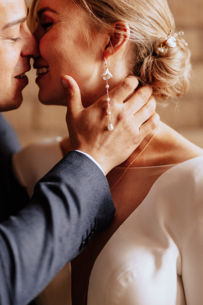 Eine Nahaufnahme eines Paares, das sich gerade küsst, wobei die Hand des Mannes sanft das Gesicht der Frau hält - die perfekte Inspiration für jeden Hochzeitsplaner, der romantische Momente sucht, oder für eine Freie Traurednerin, die eine herzliche Zeremonie ausarbeitet.